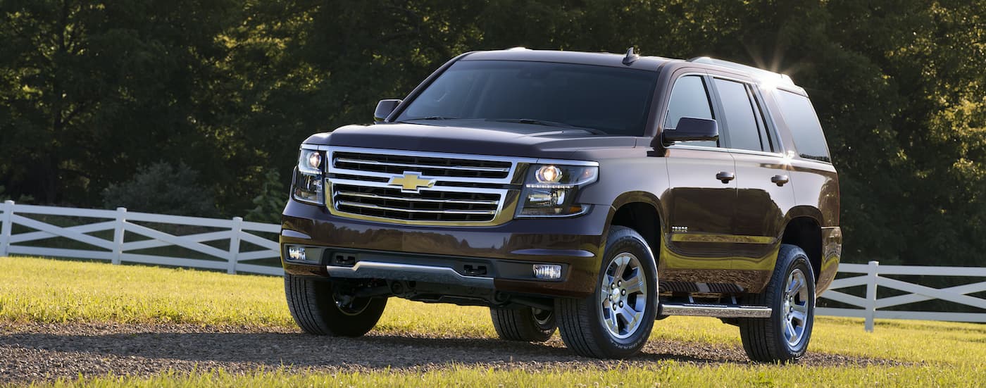 A brown 2016 Chevy Tahoe Z71 is shown from the side parked in a field.