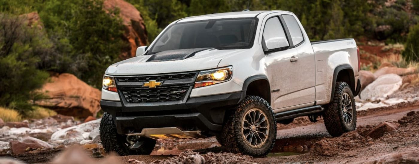 A white 2016 Chevy Colorado ZR2 is shown from the front off-roading after leaving a Certified pre-owned Chevy truck dealer.