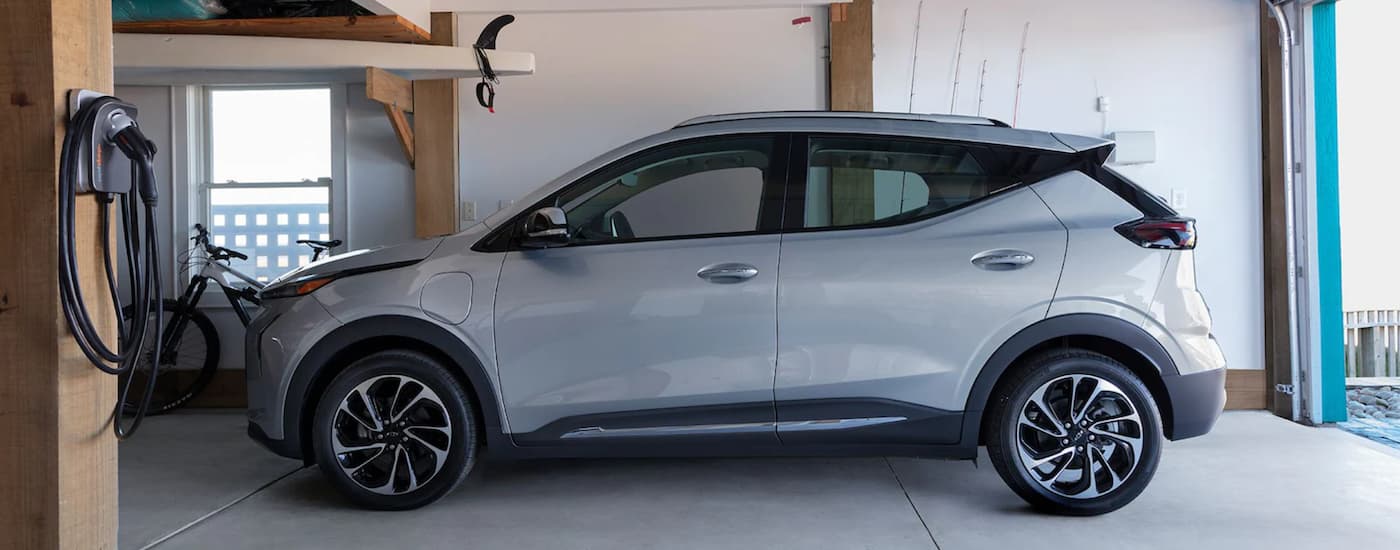 A grey 2022 Chevy Bolt EUV is shown from the side parked in a garage.