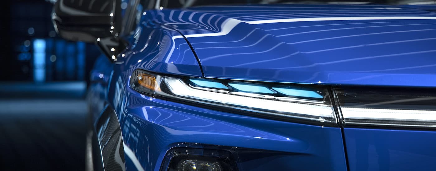 A close up shows the passenger side headlight on a blue 2024 Chevy Silverado EV RST.