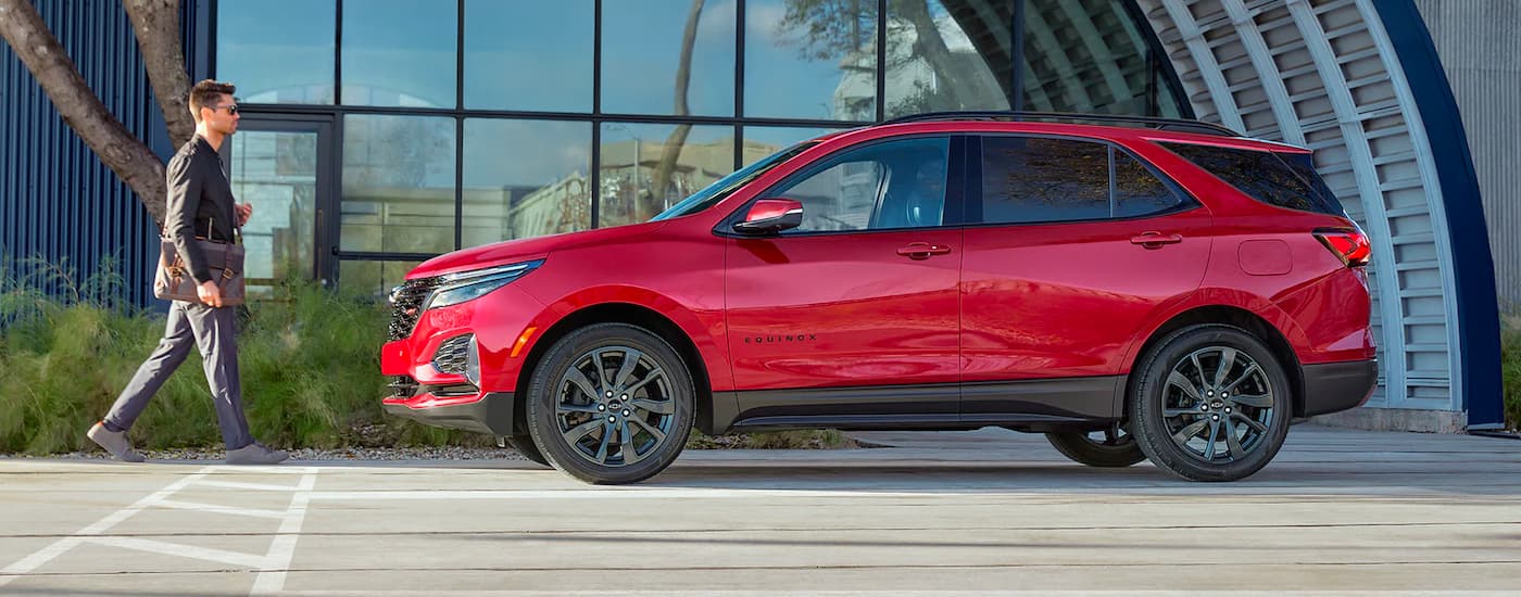 A red 2022 Chevy Equinox RS is shown in front of a building after leaving a Chevy dealer serving Tulsa.