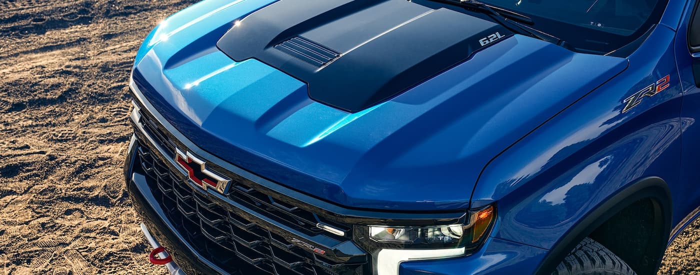 A close up shows the flow-tie badge and hood on a blue 2022 Chevy Silverado 1500 ZR2.