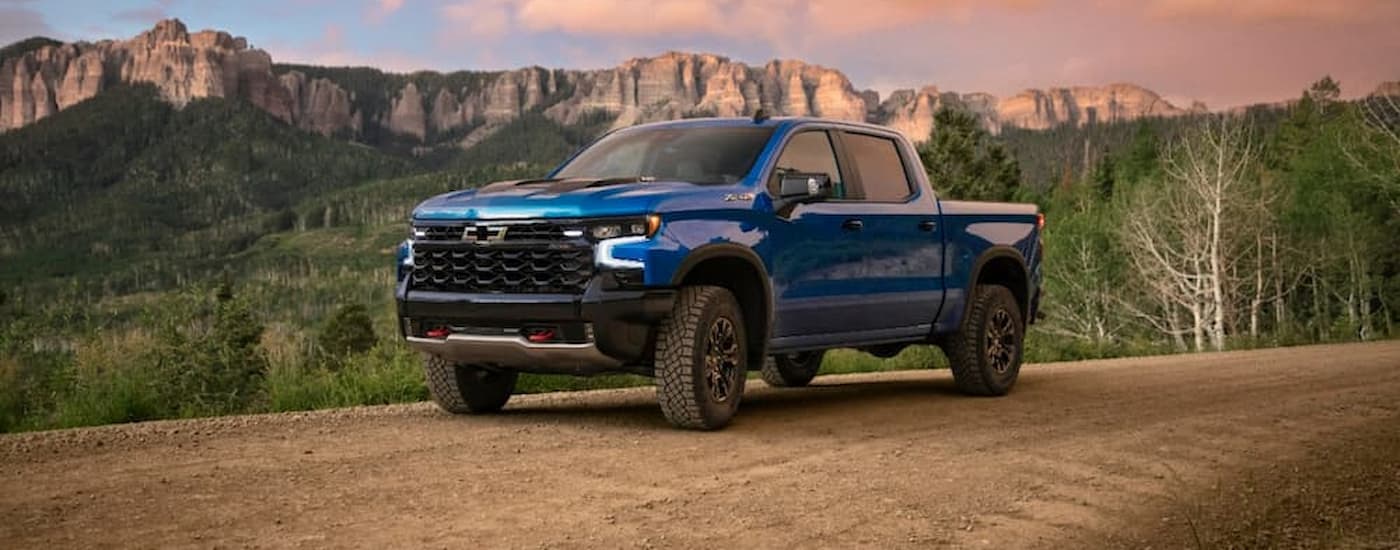 A blue 2022 Chevy Silverado 1500 ZR2 is shown from the front parked on a dirt road.