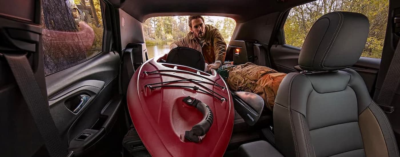 A man is shown taking a kayak out of a 2022 Chevy Trailblazer after visiting a Chevy Trailblazer dealership.