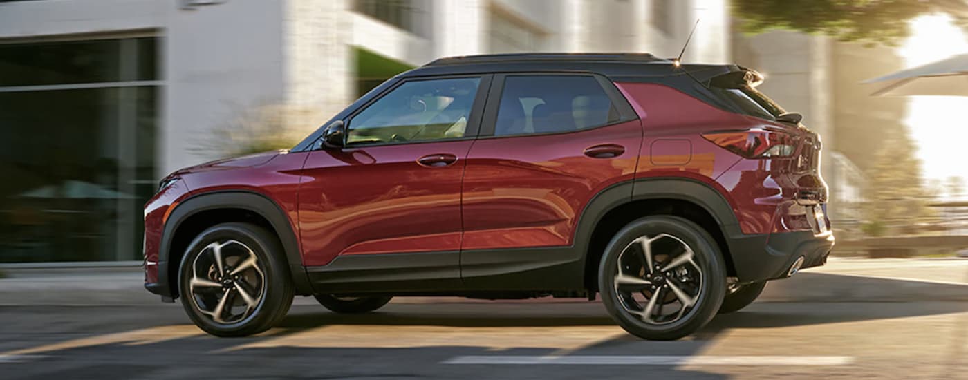 A red 2022 Chevy Trailblazer RS is shown from the side driving through a city.