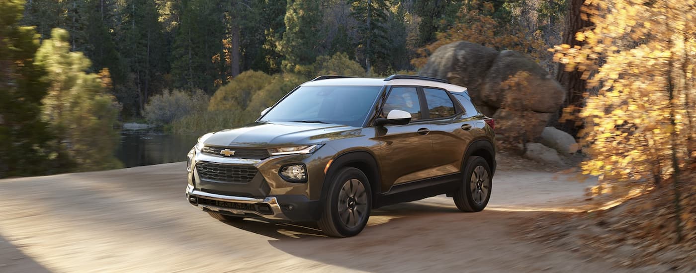 A silver 2022 Chevy Trailblazer is shown from the side driving on a dirt road after leaving a Chevy Trailblazer dealership.