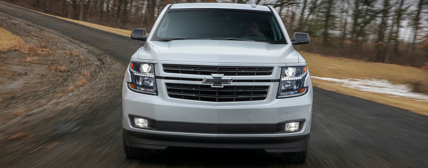 A white 2018 Chevy Tahoe RST is shown from the front driving on tarmac.