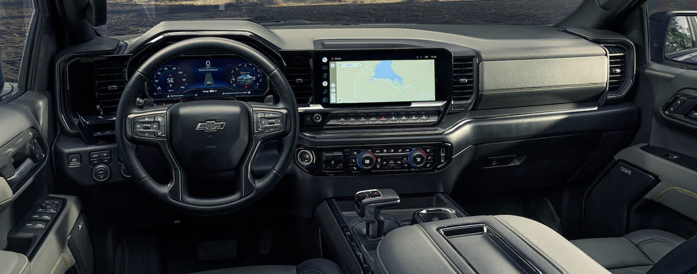 The black interior of a 2022 Chevy Silverado 1500 ZR2 shows the steering wheel and infotainment screen and steering wheel.