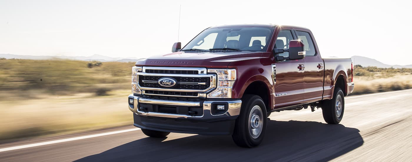 A maroon 2020 Ford F-250 is shown driving on an open road.