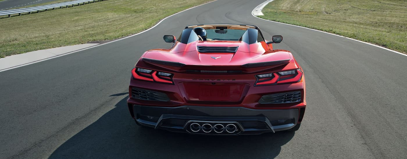 A red 2023 Corvette Z06 is shown from the rear driving on a track after leaving a Grove OK Chevrolet dealership.