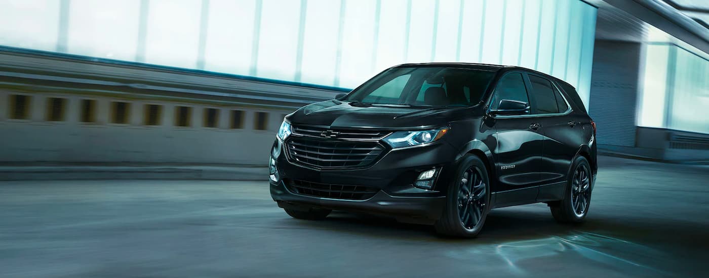 A black 2021 Chevy Equinox Midnight Edition is shown driving through a tunnel.