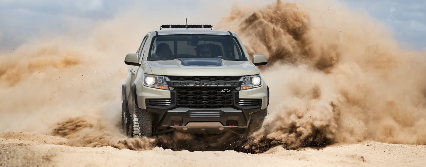 A tan 2021 Chevy Colorado ZR2 is shown from the front off-roading in the desert.