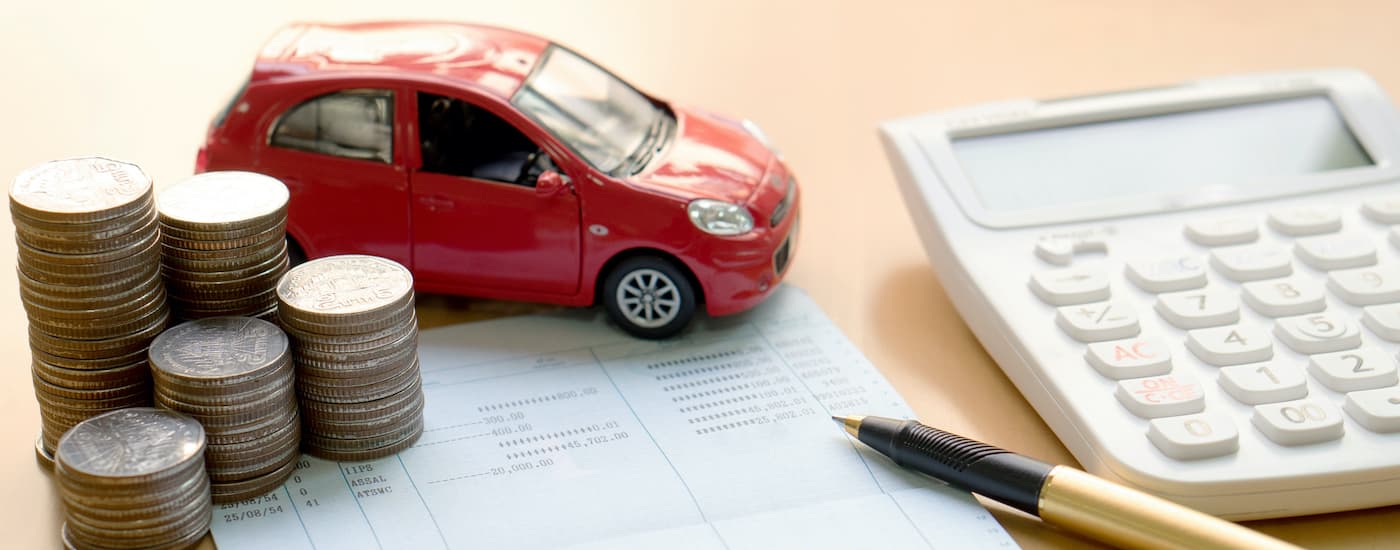 Paperwork is shown next to a toy car and a calculator.
