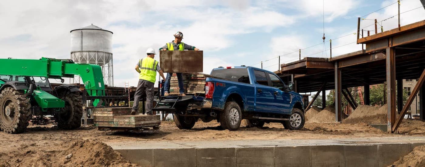 A blue 2020 Ford F-250 is shown at a construction site.