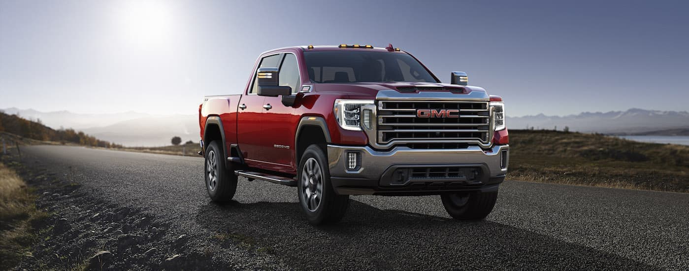 A red 2020 GMC Sierra 2500HD is shown parked on a remote road after leaving a Tulsa used truck dealership.