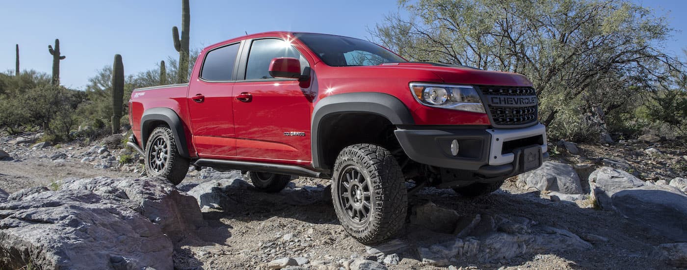 A red 2019 Chevy Colorado ZR2 Bison is shown off-roading in the desert after leaving a Tulsa used truck dealership.
