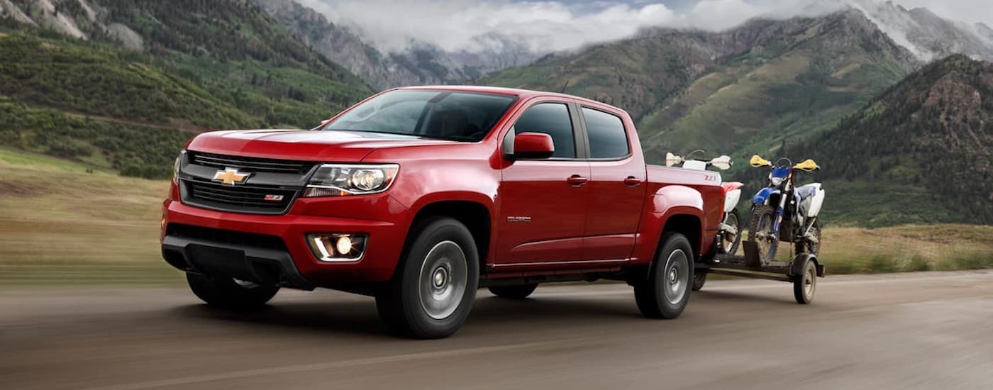 A red 2020 Chevy Colorado is shown from the side driving on an open highway.