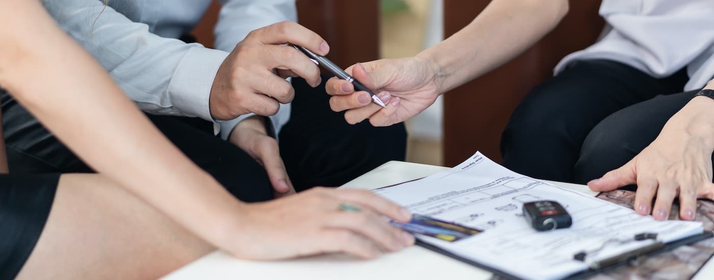 Customers are shown filling out paperwork at a Tulsa dealership.