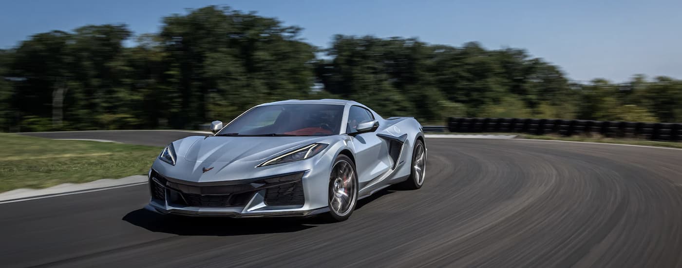 A silver 2023 Chevy Corvette Z06 is shown driving on an open track.