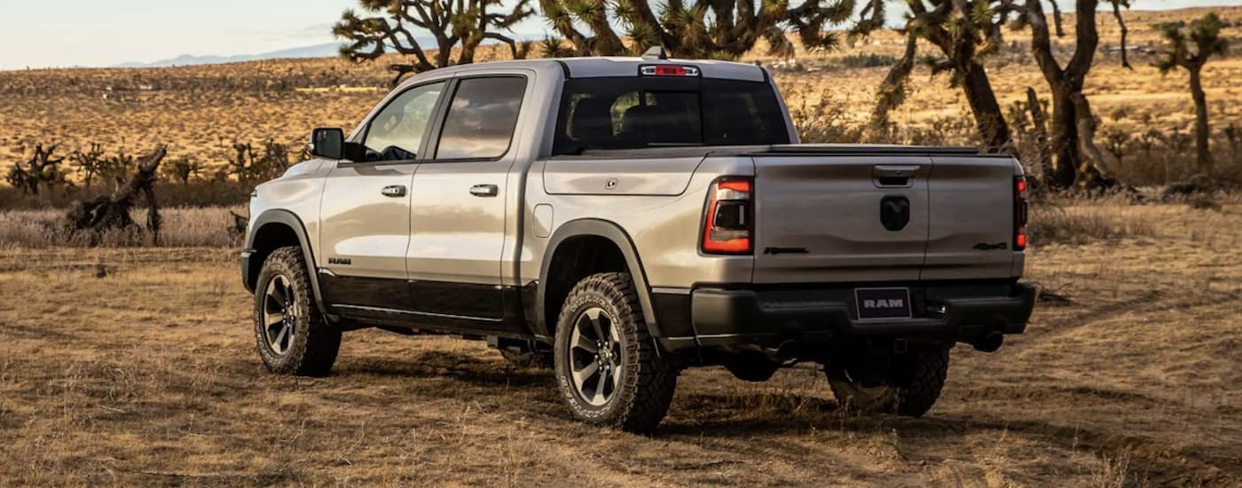 A grey 2021 Ram 1500 is shown from the side off-roading after leaving a used truck dealership.