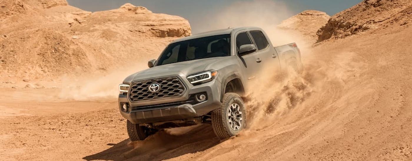 A tan 2020 Toyota Tacoma TRD is shown off-roading in a desert.
