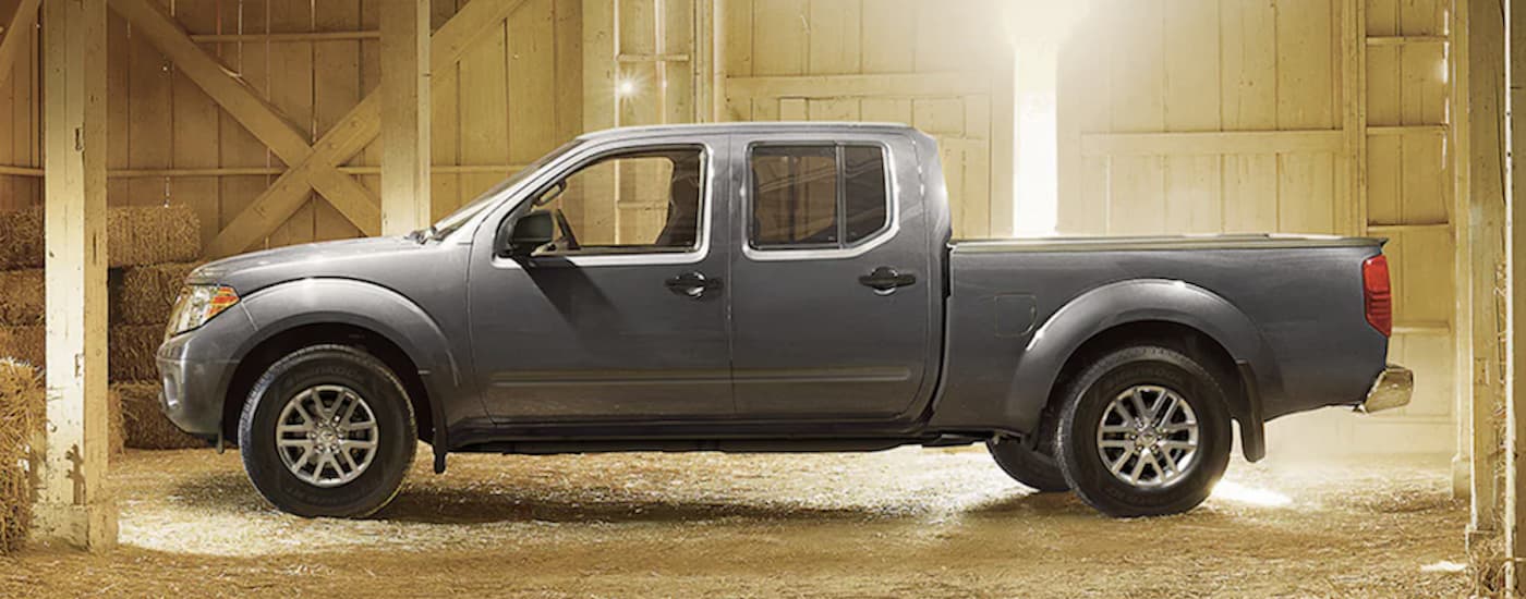 A grey 2021 Nissan Frontier PRO-4X is shown from the side parked in a barn.